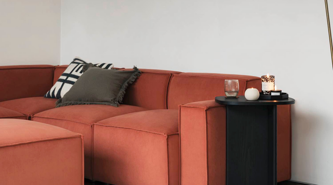 red velvet sofa with white walls and black side table