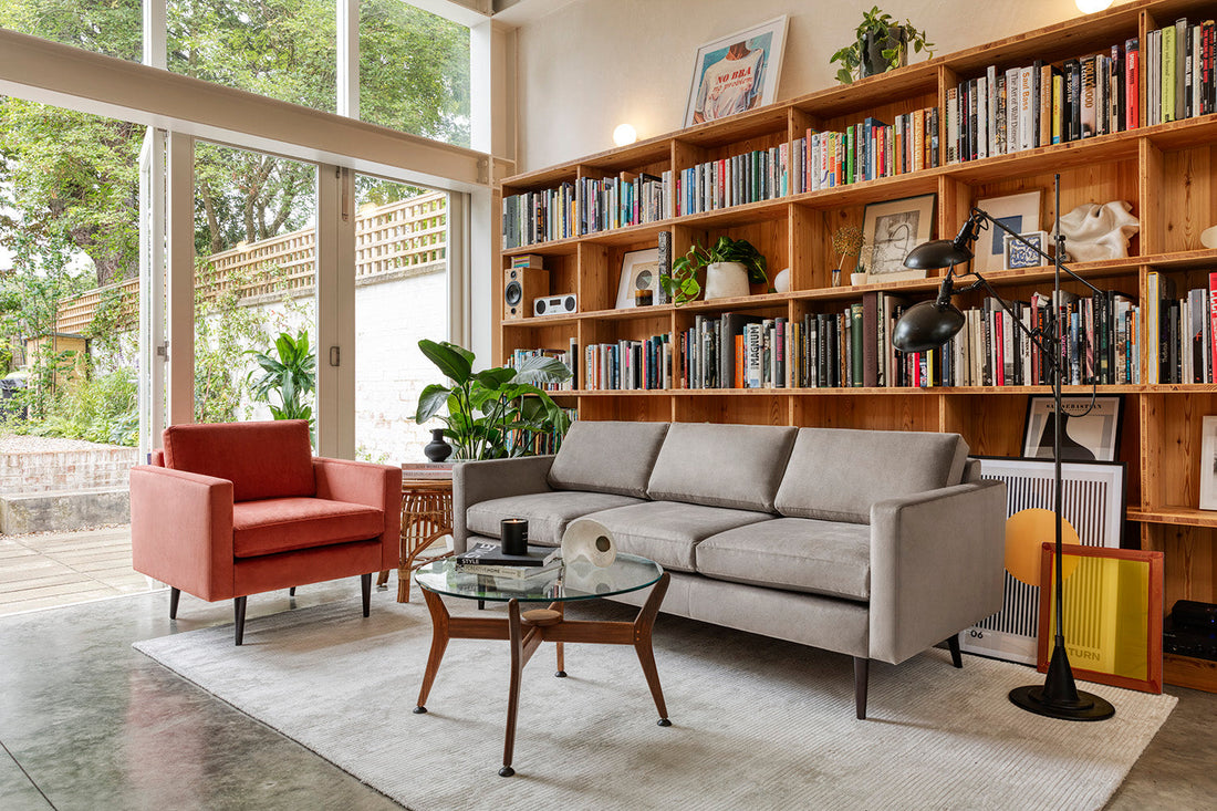 living room with bookcase, grey sofa and red/orange armchair